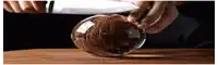 a person is cutting a coconut with a knife on a wooden table