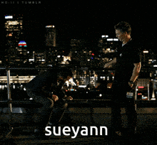 two men are standing on a balcony and the word sueyann is on the bottom