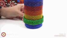 a person is playing with a rainbow colored bracelet made of magnets