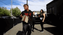 a man with a gucci bag on his shoulder walks down a street