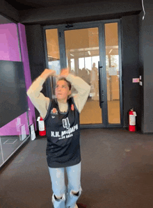 a woman wearing a basketball jersey that says n.i.i. basketball on it