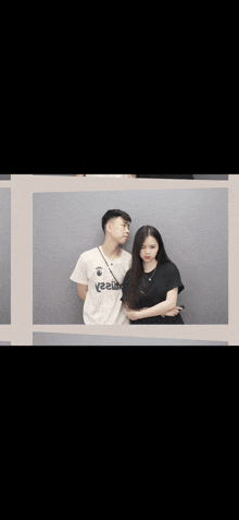 a man and a woman are posing for a picture and the man is wearing a white shirt that says reebok