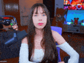 a woman with long hair is sitting in front of a microphone with a keychain on it