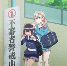 two girls are standing in front of a sign with chinese writing on it