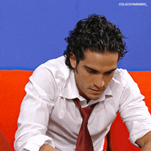 a man with curly hair wearing a white shirt and tie