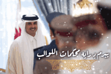 a man in a white robe stands in front of a sign that has arabic writing on it