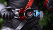 a person wearing a black shirt and a red belt with a red circle with the letter m on it