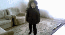 a person wearing a mask is standing in a living room with chairs .