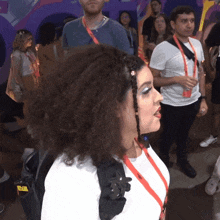 a woman wearing a lanyard that says ny stands in a crowd
