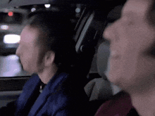 a man in a blue suit is sitting in the back seat of a car