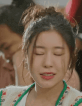 a close up of a woman with her eyes closed .