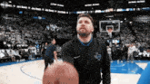 a man wearing a texas shirt is holding a basketball on a basketball court