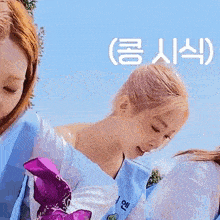 a woman in a white shirt is holding a purple windmill while another woman looks on