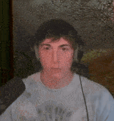 a man wearing headphones and a tie dye shirt looks at the camera
