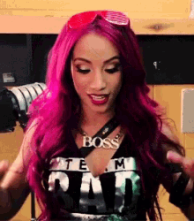 a woman with pink hair is wearing a necklace that says boss on it