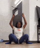 a woman is squatting on the floor in front of a door