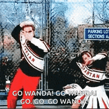 a group of cheerleaders are dancing in front of a parking lot .