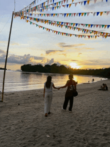 two people holding hands on a beach and one has the number 33 on his shirt