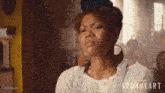 a woman is wearing a white shirt and overalls with the word ironheart on the bottom