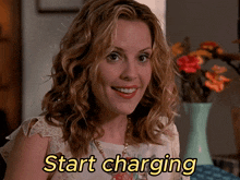 a woman with curly hair is smiling with the words start charging above her