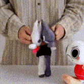 a person in a striped shirt is holding a stuffed animal in their hands ..