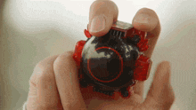 a person is holding a black object with a red circle around it