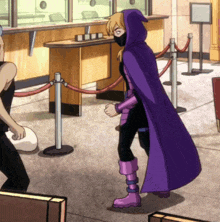 a woman in a purple cape is standing in front of a red rope barrier