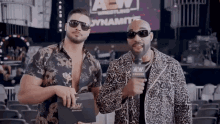 two men standing next to each other in front of a sign that says aew