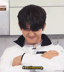 a young man with his arms crossed and a #wetjinyoung sticker