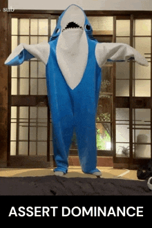 a person in a blue and white shark costume with the words assert dominance below them