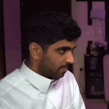 a man in a white shirt is looking at something