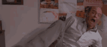 a man in a lab coat is throwing papers in the air while sitting in an office chair .
