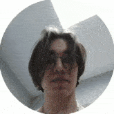 a man with long hair and glasses is in a white circle