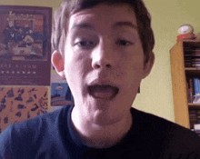 a young man is making a funny face in front of a poster for the album