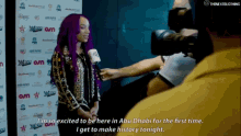 a woman with purple hair is talking to a reporter