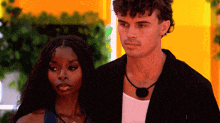 a man and a woman are standing next to each other and looking at something