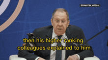 a man in a suit and tie is talking into a microphone and the caption says then his higher ranking colleagues explained to him