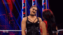 two women are hugging each other in a wrestling ring on a wrestling show .