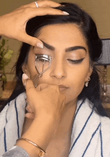 a woman is getting her eyebrows curled by someone