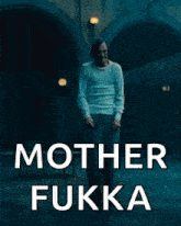 a man in a white shirt is standing in front of a building with the words `` mother fukka '' written on the bottom .