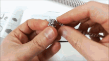 a close up of a person 's hands holding a metal object