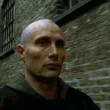 a close up of a man 's face with a shaved head