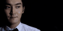 a man in a white shirt and black bow tie is making a face .