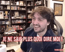 a man sitting in front of a microphone with the words je ne sais plus quoi dire moi in red