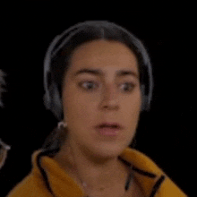 a woman wearing headphones is making a surprised face with her tongue out .