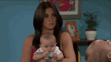 a man is holding a baby while a woman holds another baby