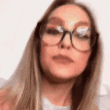 a close up of a woman wearing glasses making a funny face