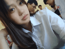 a girl in a white shirt with a red tie is taking a picture