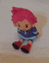 a toy with a purple jacket and blue sleeves is laying on the ground