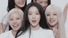 a group of women are posing for a picture and one of them is wearing a white t-shirt
